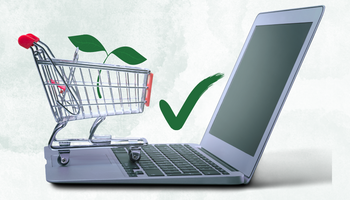 A laptop with a shopping trolley containing a green leaf. Next to it is a check tick