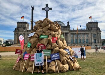 Protest mit Schuldensäcken vor dem deutschen Reichstagsgebäude für eine bessere internationale Finanzarchitektur